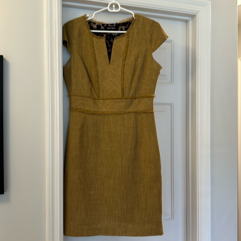 Tan sheath dress with fringe details.
